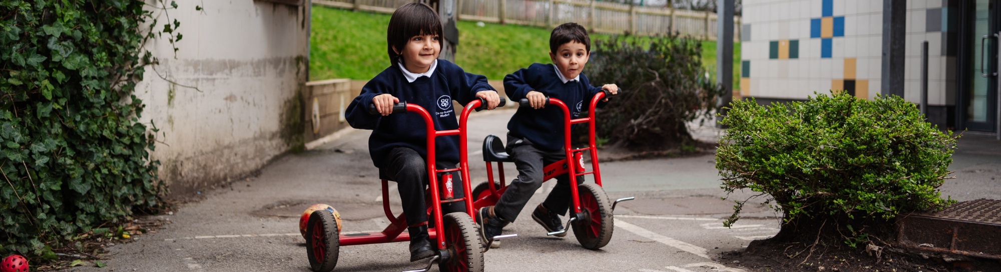 Header image showing children on tricycles